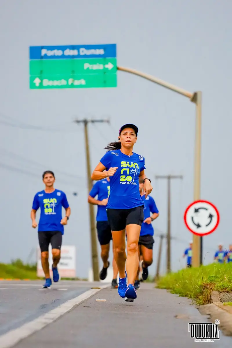 Corredora com camiseta azul da corrida Sunrise Run