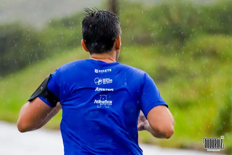 Corredor de costas com camiseta azul estampada com os patrocinadores