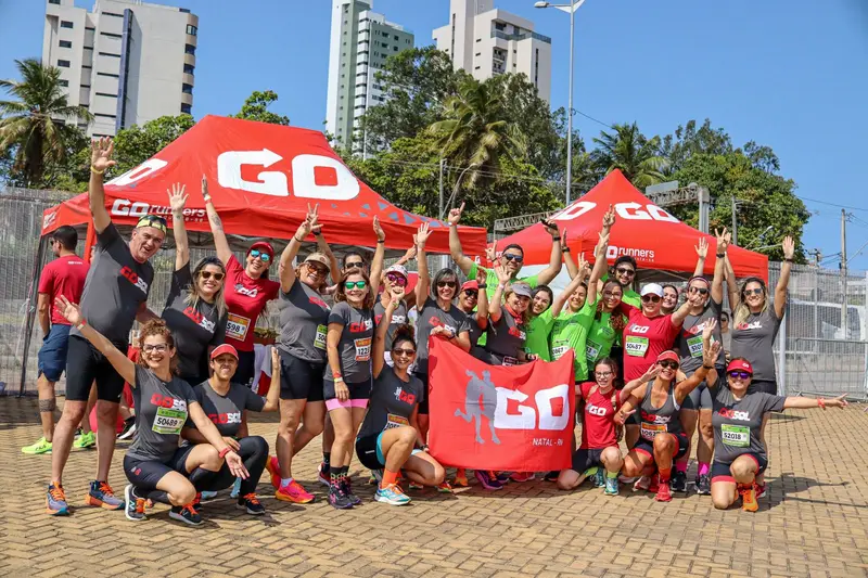 Equipe GO Runners com camisetas personalizadas em frente à tenda do evento